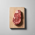 Steak on a wooden cutting board with a gray background